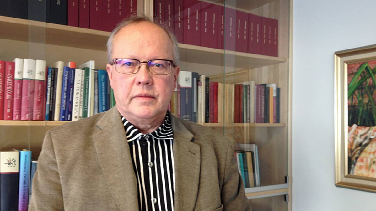 Antti Kejo poseeraa hyllyn edessä.