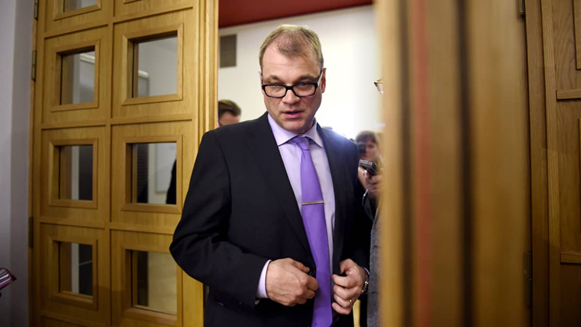 Juha Sipilä kulkee ovesta.