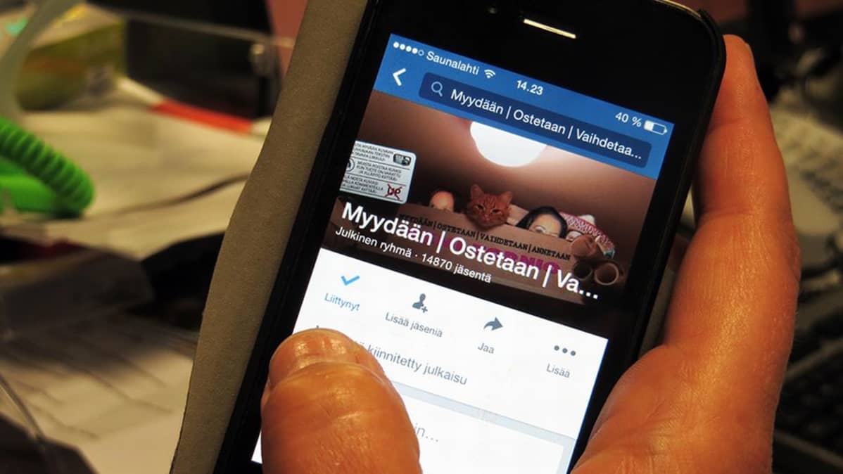 Facebook-kirpputoriryhmää selataan kännykän näytöltä.