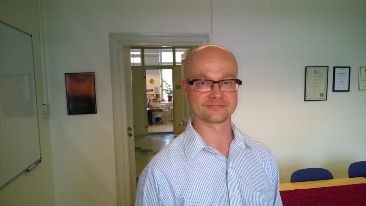 Tuomas Martikainen seisoo huoneessa.