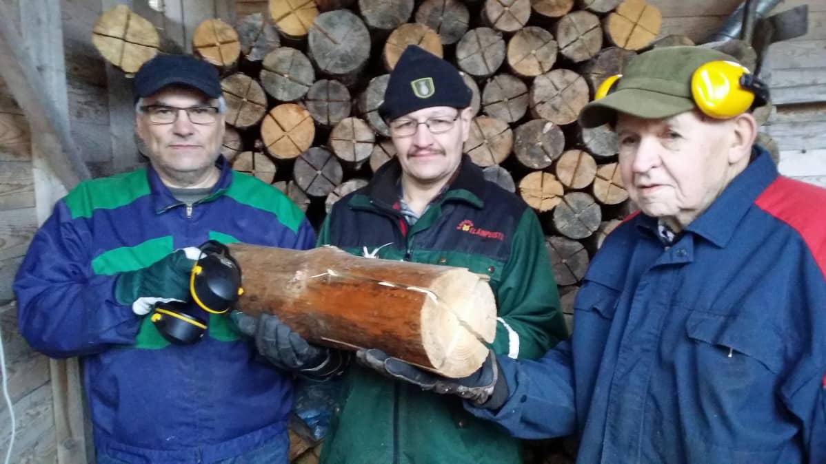 Pölkkymestarit Tapio Oikari (vas.), Jarmo Soukkala ja Heikki Raikamo jätkänkynttiläpinon edessä.