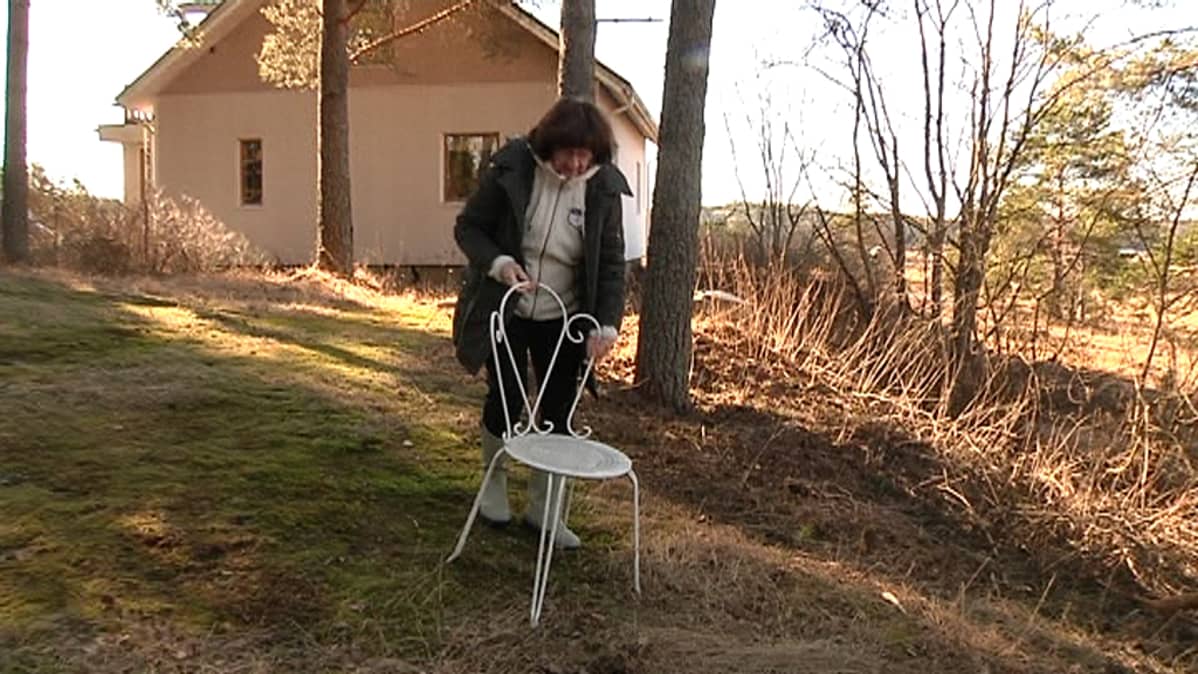 Nainen kantaa tuolia