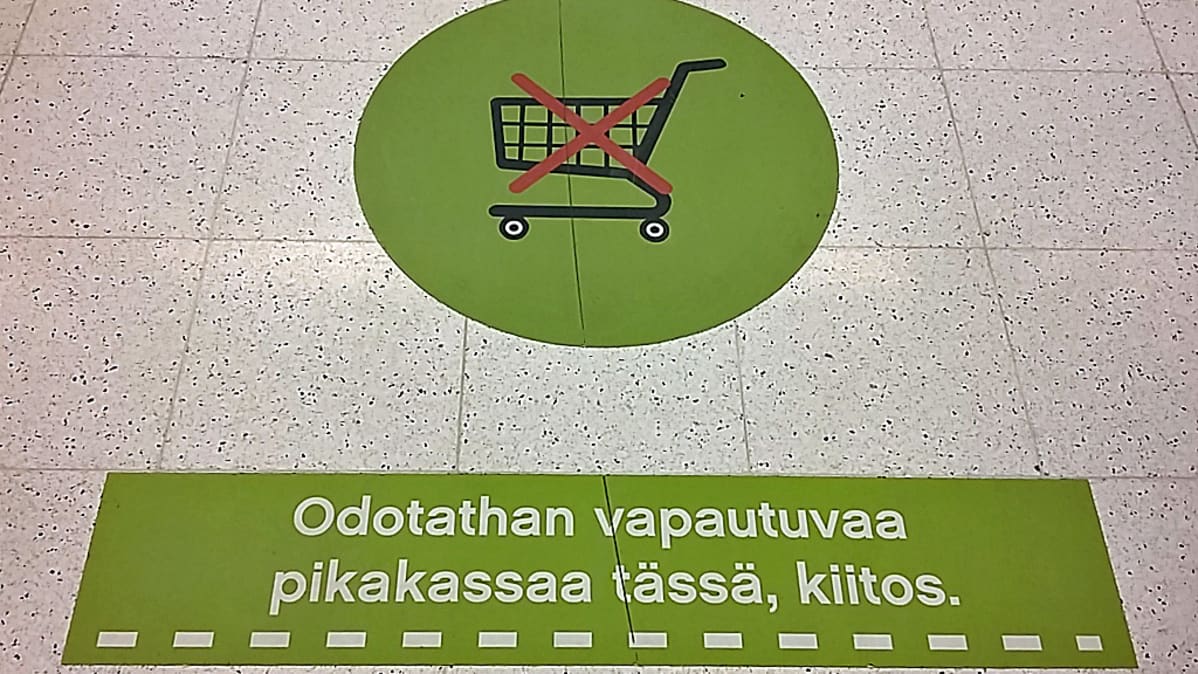Jonotusviiva pikakassan edessä lattialla.