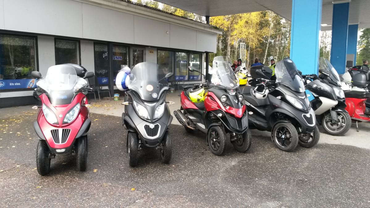 Kolmipyöräisiä skoottereita huoltoaseman edessä