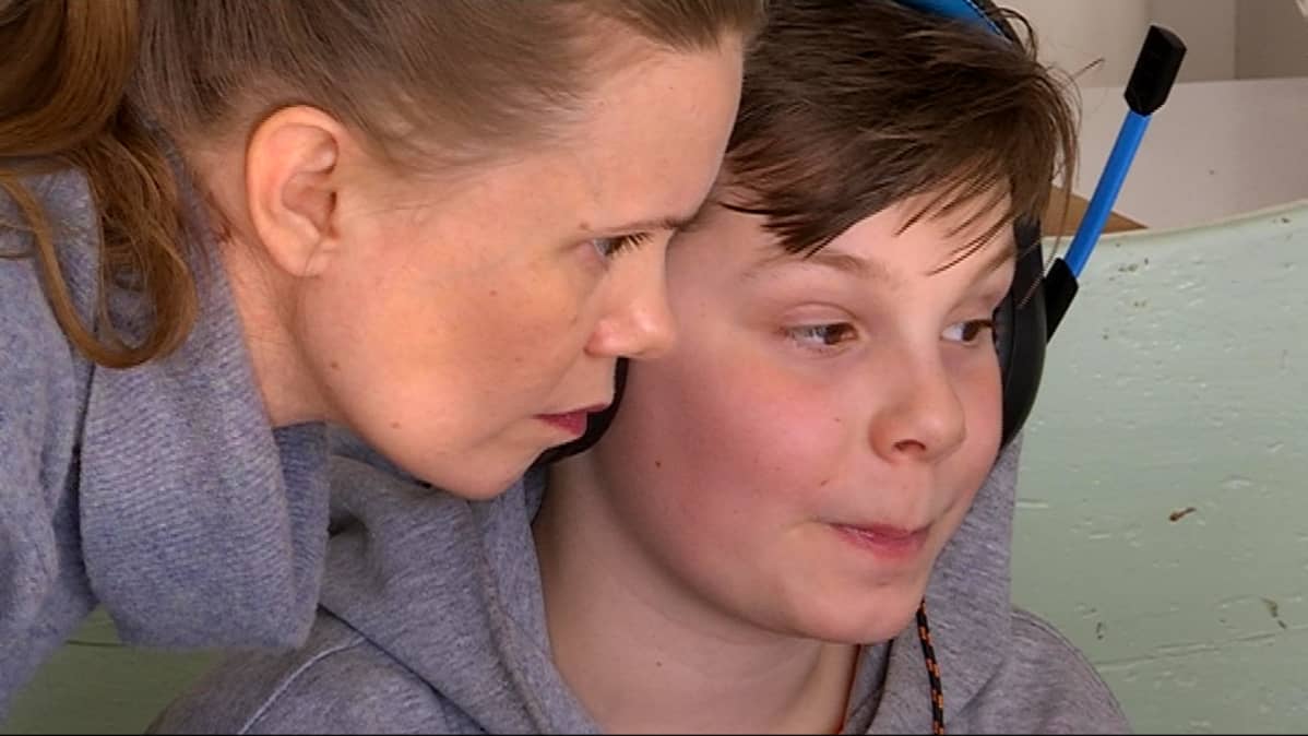 Karoliina Juhola auttaa poikaansa Mihku Näkkäläjärveä etätunnilla ilmaantuneissa teknisissä ongelmissa.