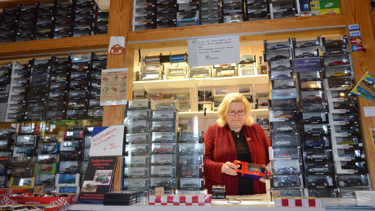 Leila Suutarinen kioskissa pienoismallien ympäröimänä.