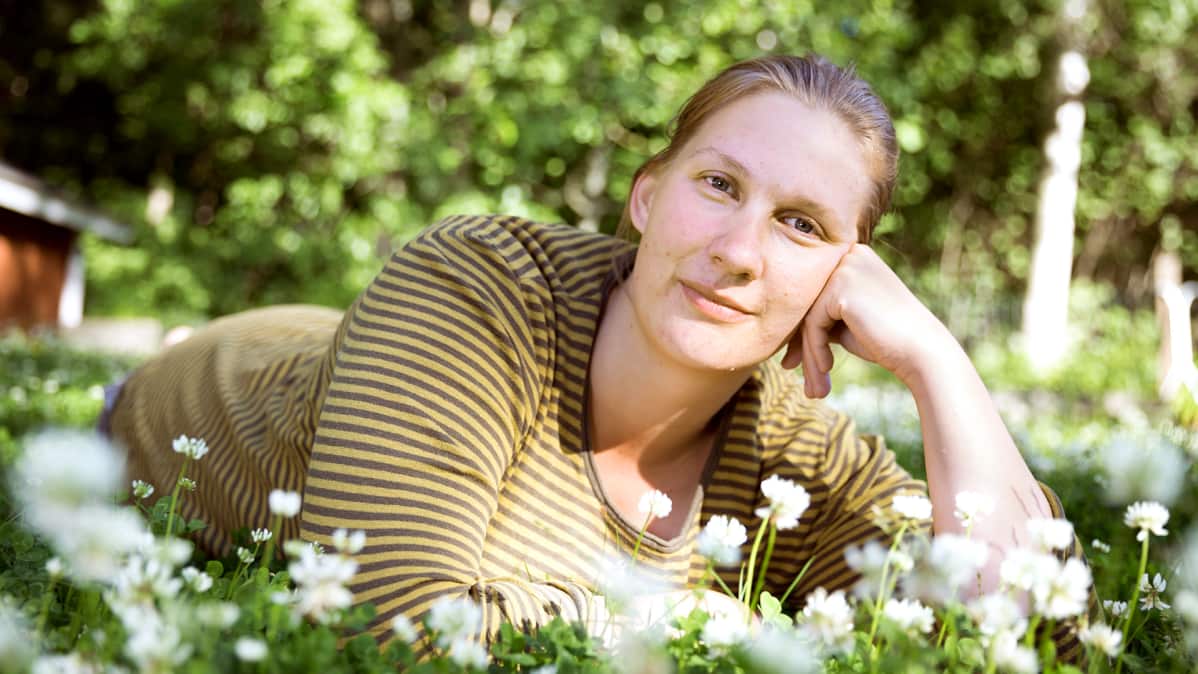 Mikaela Sundman makoilee nurmikolla.