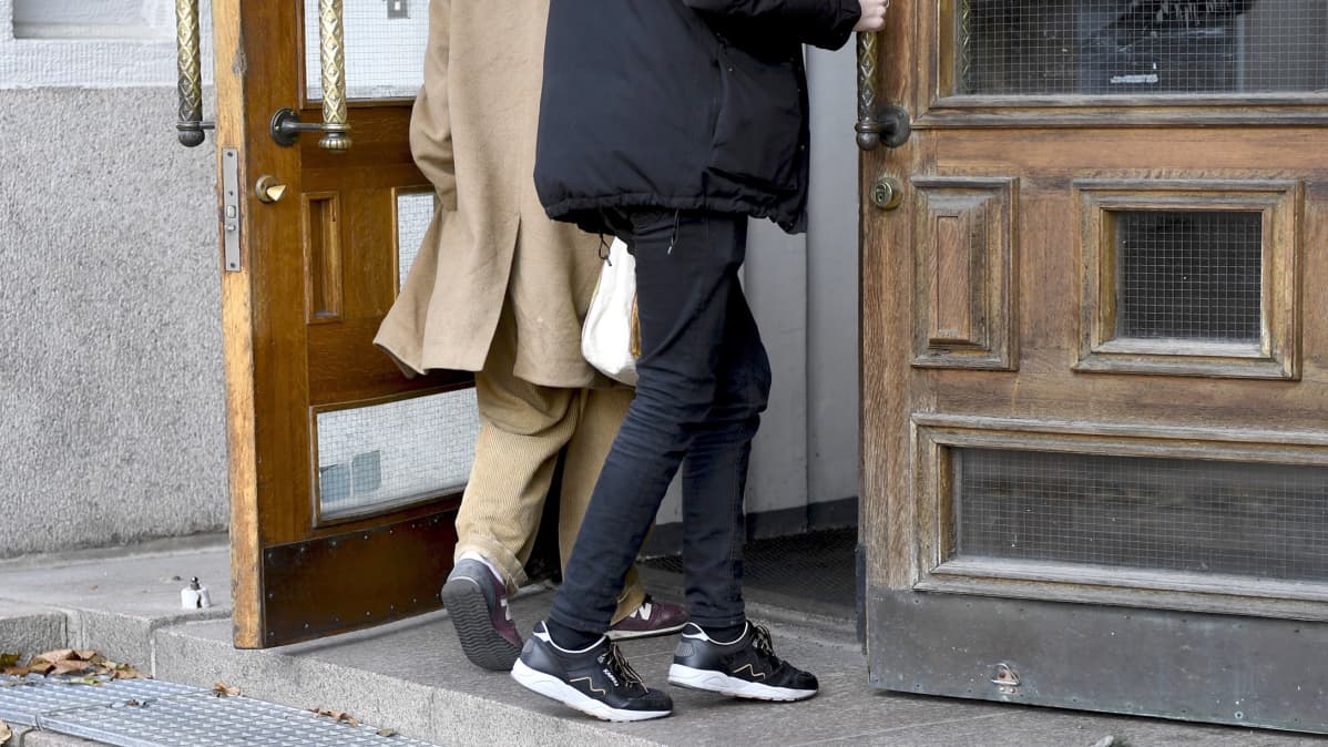 kaksi miestä menee ovesta sisään