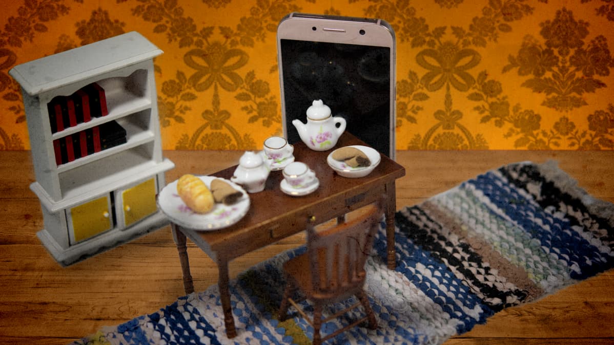 Kuvituskuva, jossa kännykkä seisoo olohuoneessa.
