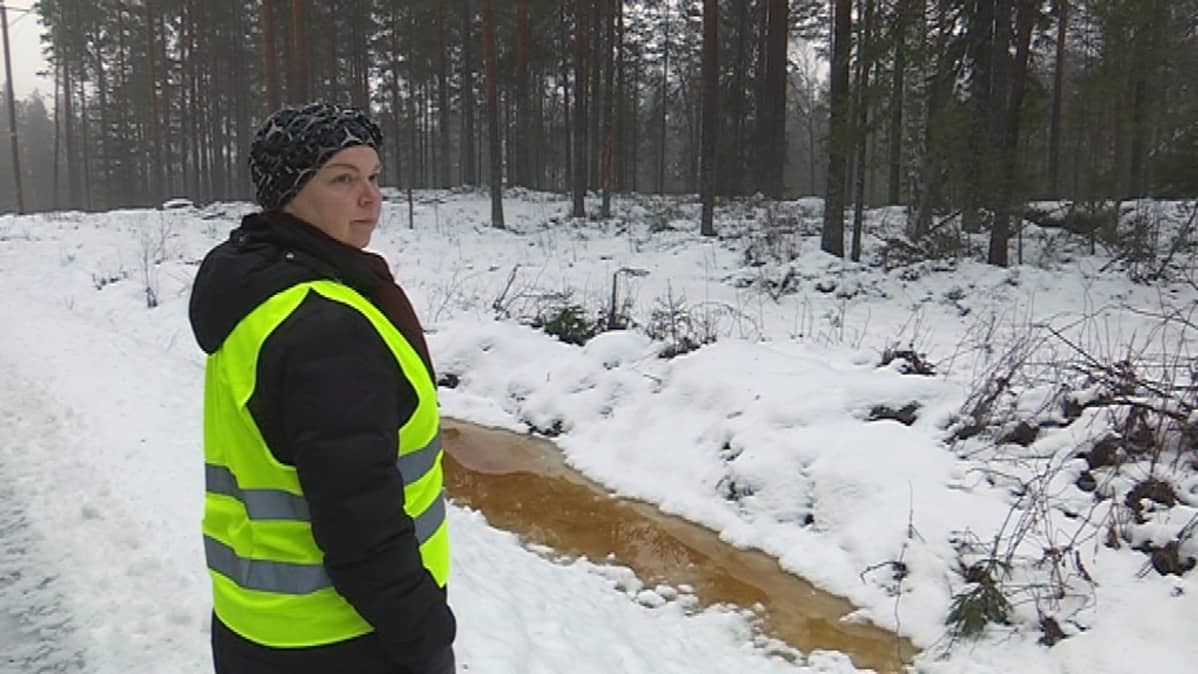 nainen, Tanja Mynttinen, tieisännöitsijä seisoo talvella vetisen ojan vierellä asivutien reunalla, yksityistiet