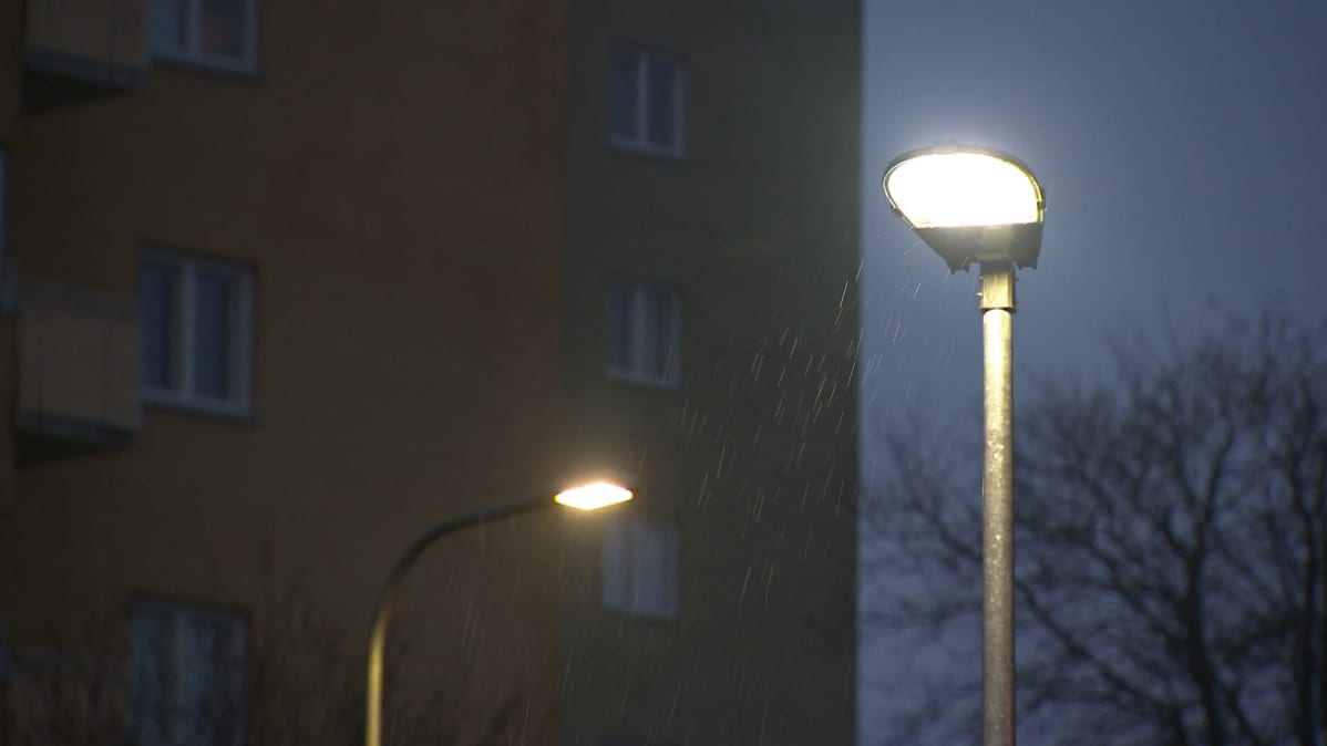 Två gatulampor lyser i regnigt väder.