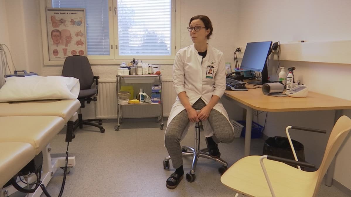 Yleislääketieteen erikoislääkäri Jenni Merimaa istuu työpöytänsä ääressä.