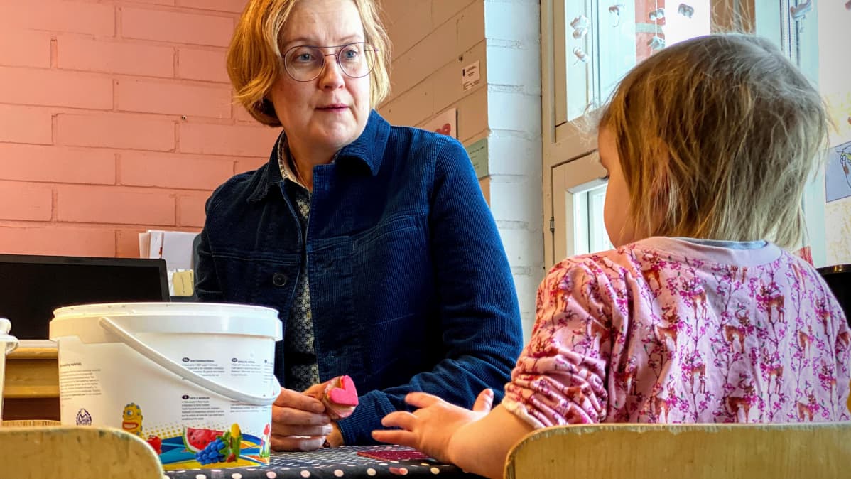 Varhaiskasvatuksen psykologi Nina Sassali askartelemassa lasten kanssa oululaisessa päiväkodissa.