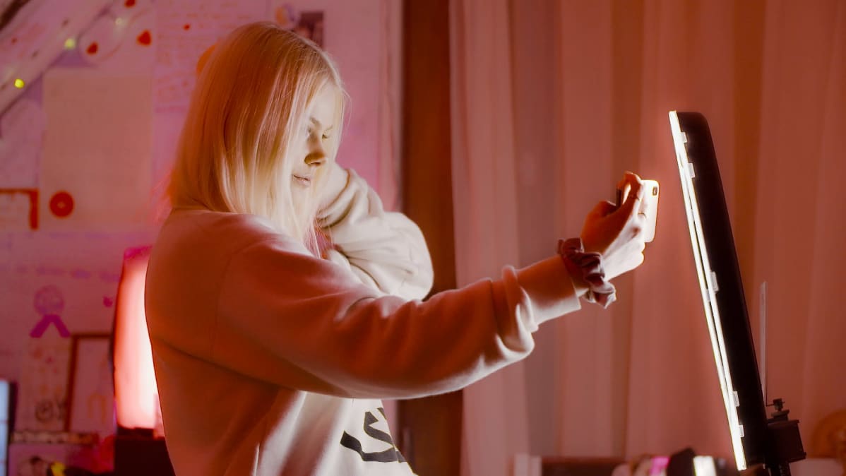 Jennifer Käld kuvaa TikTok-videota huoneessaan kuvausvalon edessä.