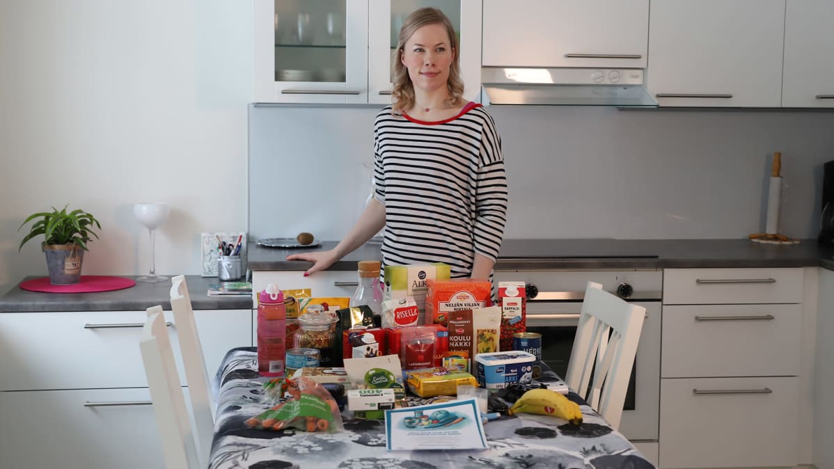 Paula Aho poseeraa ruokavarastojensa takana.