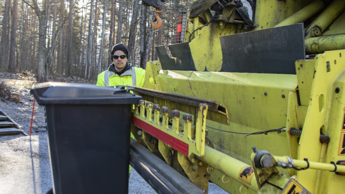Janne Katila tyhjentämässä jäteastiaa.