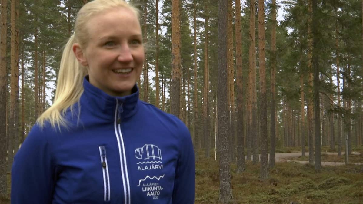 Projektipäällikkö Henna Matintupa seisoo metsässä