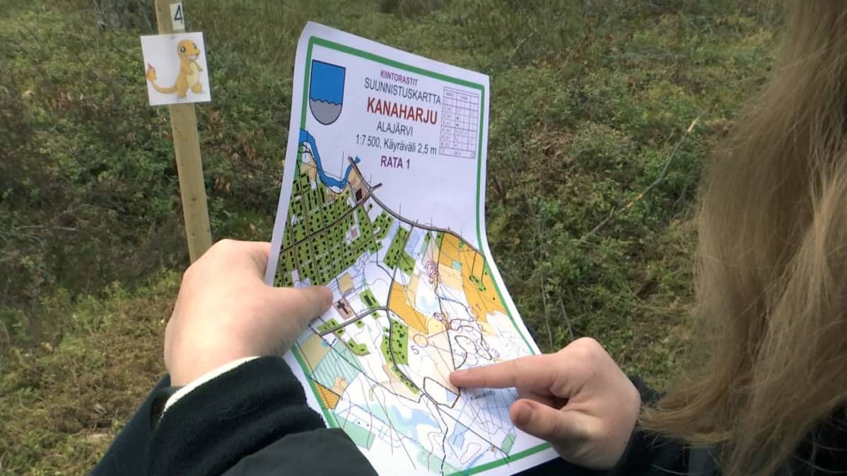 Tyttö katsoo karttaa Alajärven Pokemon-suunnistusradalla