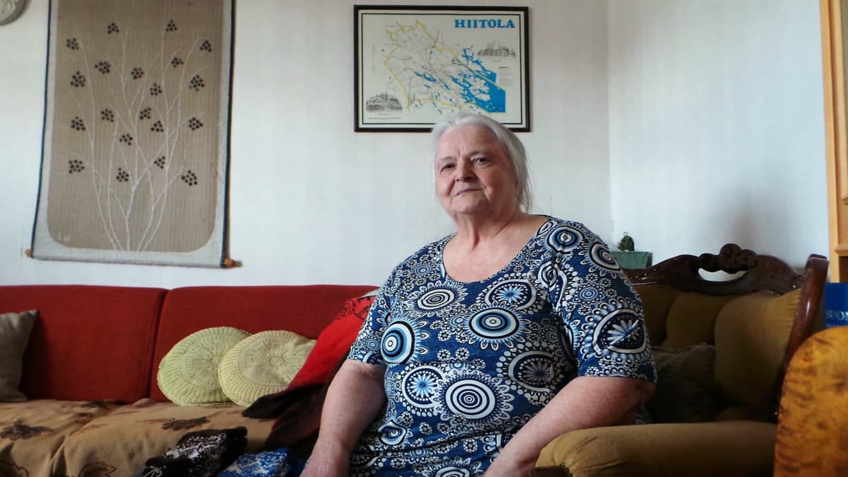 Marja-Liisa Isoviita istuu nojatuolilla ja hymyilee