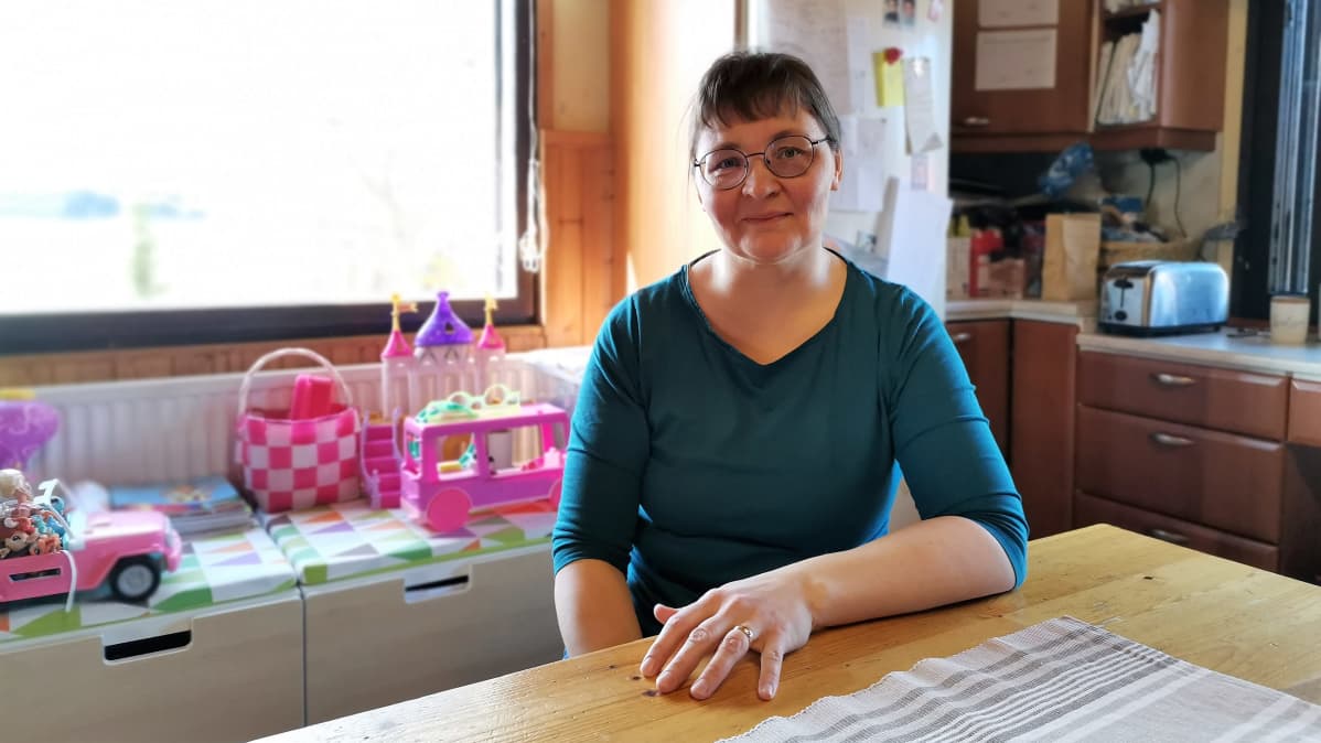 Sari Korvala istuu pöydän ääressä.