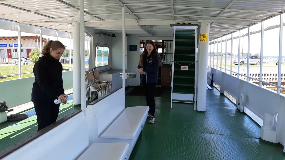 Lotta Järvi ja Sofi Berg desinfioivat M/S Jennyn sisätiloja.