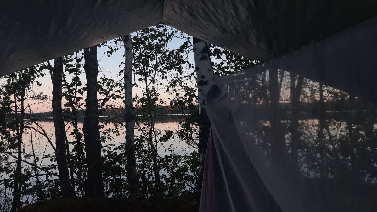 Riippumatto järven rannalla rauhallisessa kesäillassa