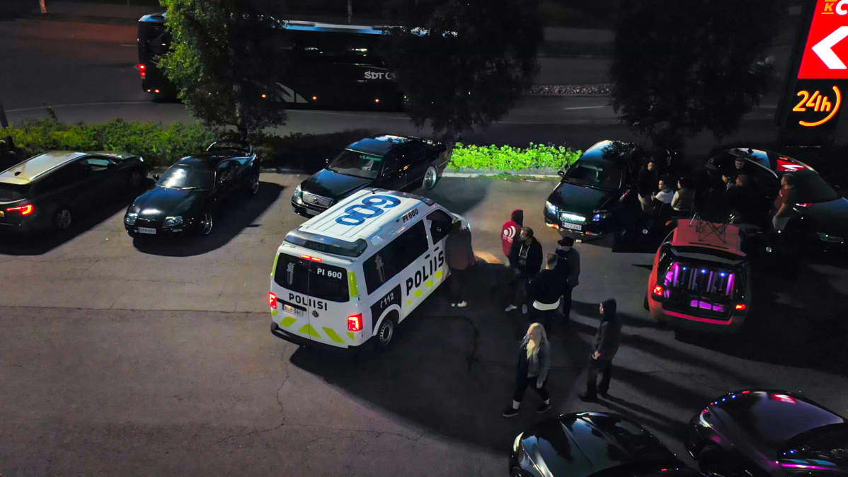 Poliisiauto on pysähtynyt toisten autojen viereen.