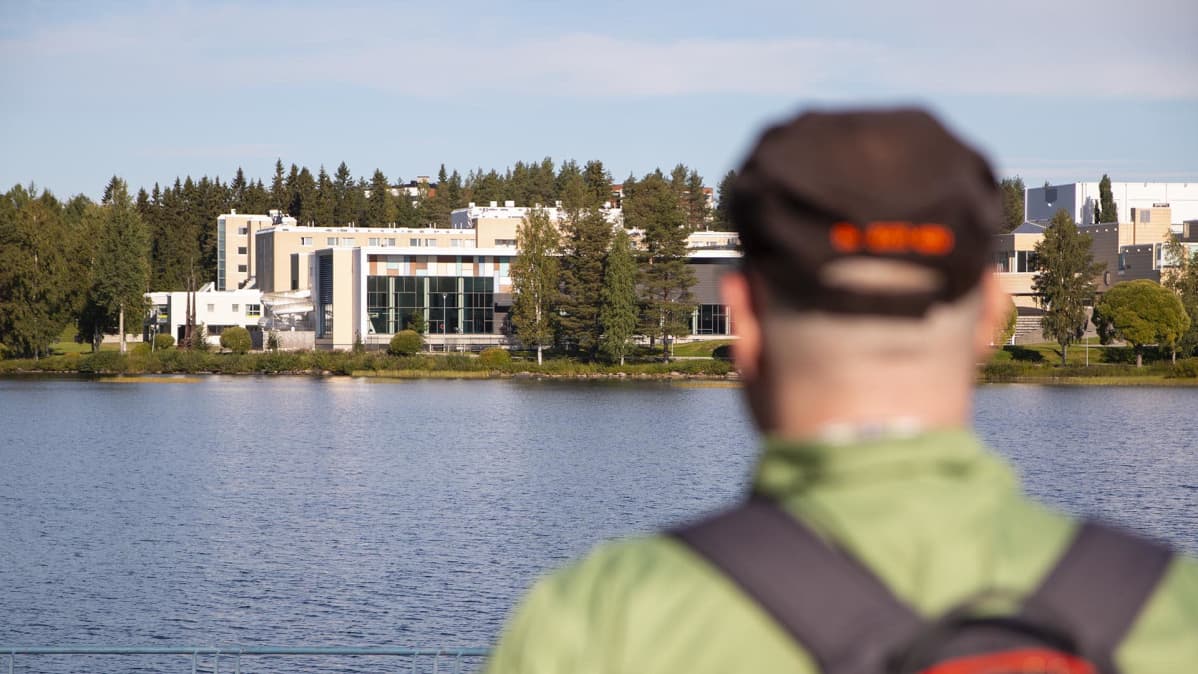 Veli Huovinen katsoo joen toisella puolella olevaa Vesi- ja liikuntakeskus Kaukavettä.