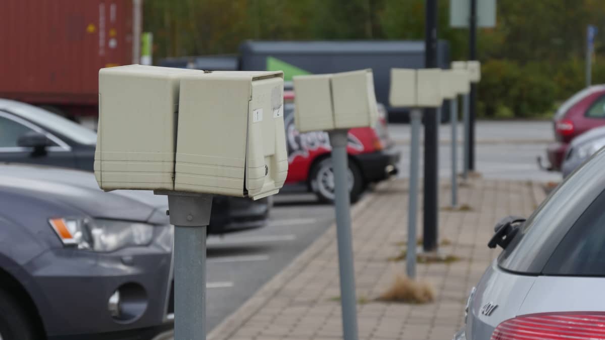 Parkkipaikka, jossa rivissä auton lämmitystolppia.
