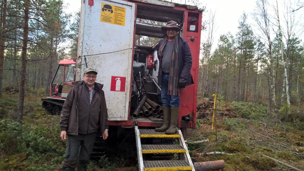 Kaksi miestä poseeraa pakettiauton takana