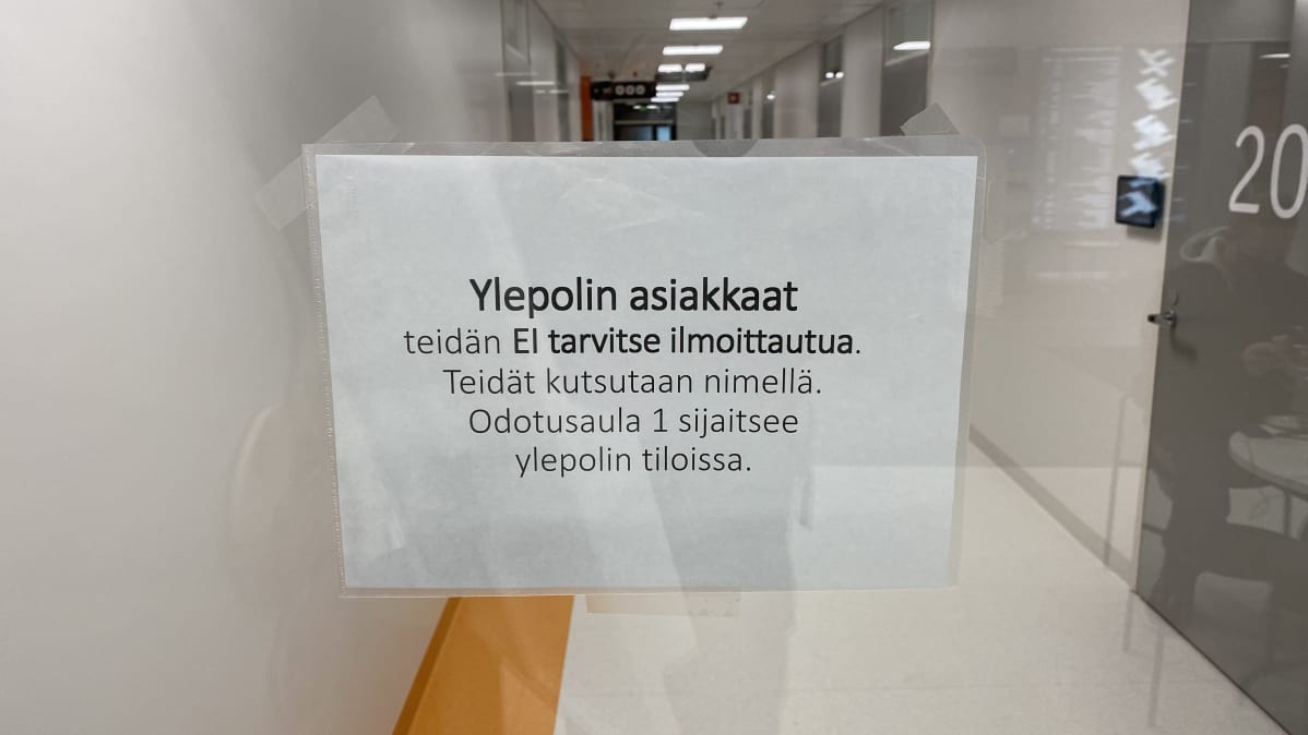 Lasiovessa oleva tiedote asiakkaille sairaalassa asioinnista.