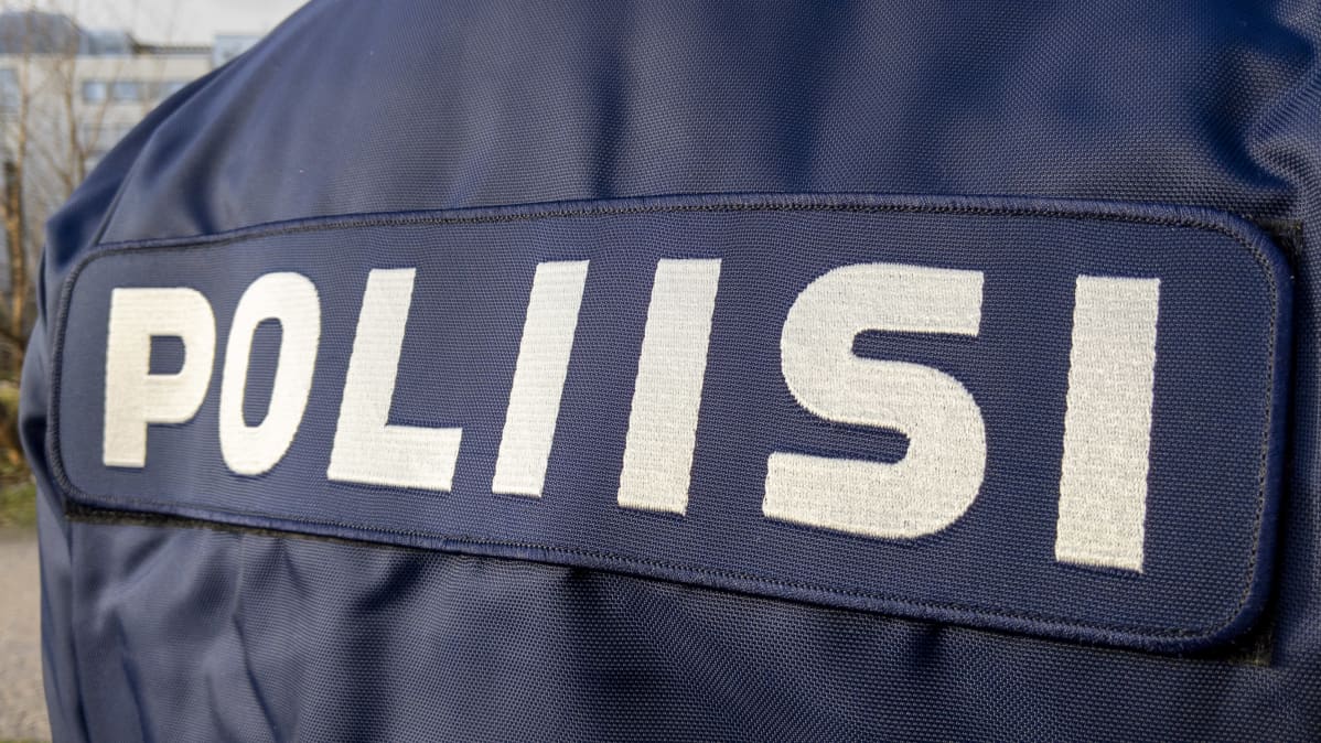 Poliisi teksti poliisihenkilön selässä.
