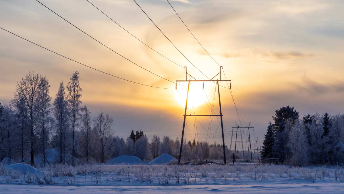 Voimalinja Limingassa ja aurinko, joka paistaa pilvien takaa. Tilastokeskuksen mukaan uusiutuvilla energialähteillä katettiin lähes 38 prosenttia energian kokonaiskulutuksesta vuonna 2019. Uusiutuvien osuus kasvaa tasaisesti.