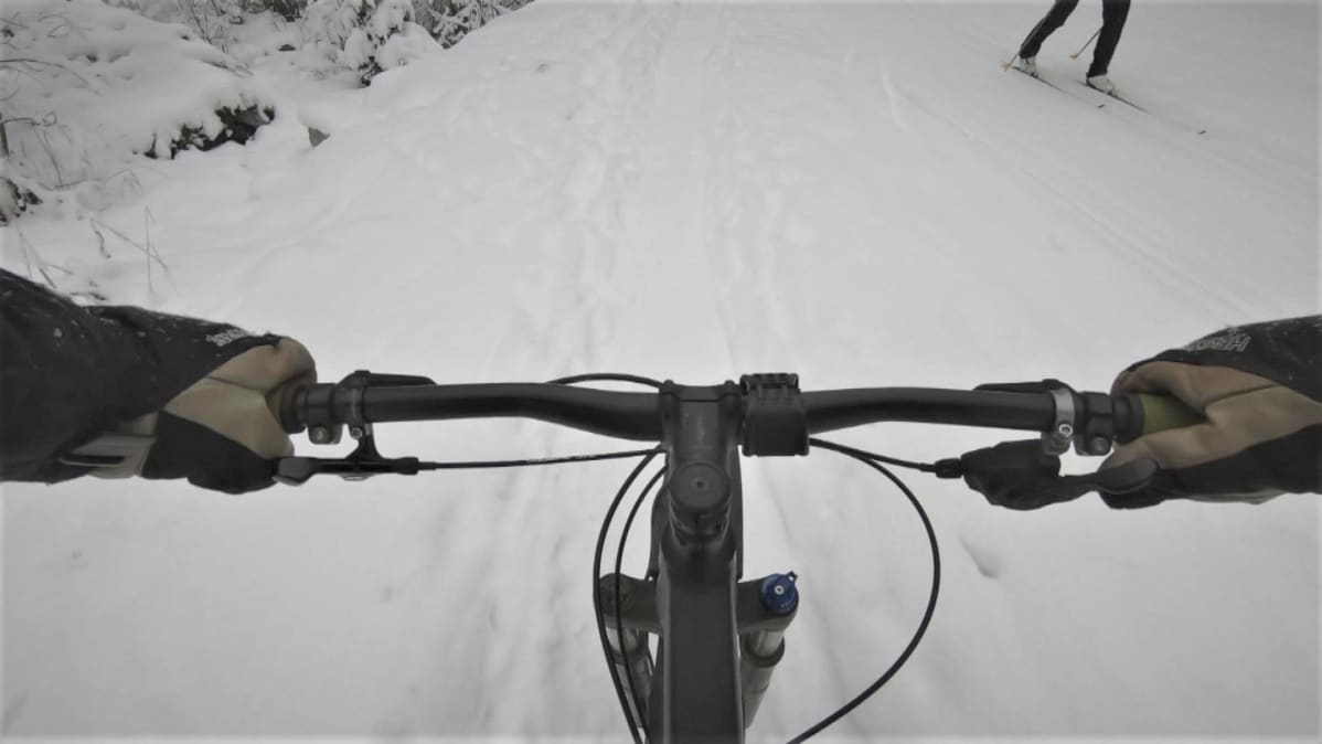 maastopyöräilijä lumisella ajoreitillä
