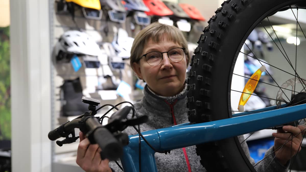 Merja Mutka pyöränrungon takana Pyöräpoikien myymälässä