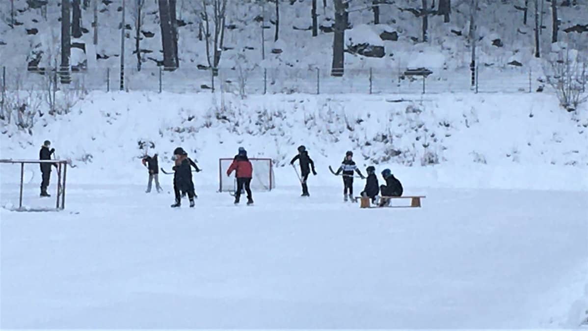 Koululaisia luistelemassa koulun kentällä