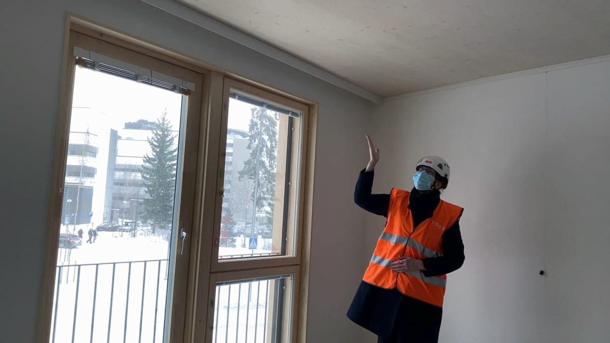TOASin toimitusjohtaja Kirsi Koski osoittaa opiskelija-asunnon puista kattoa