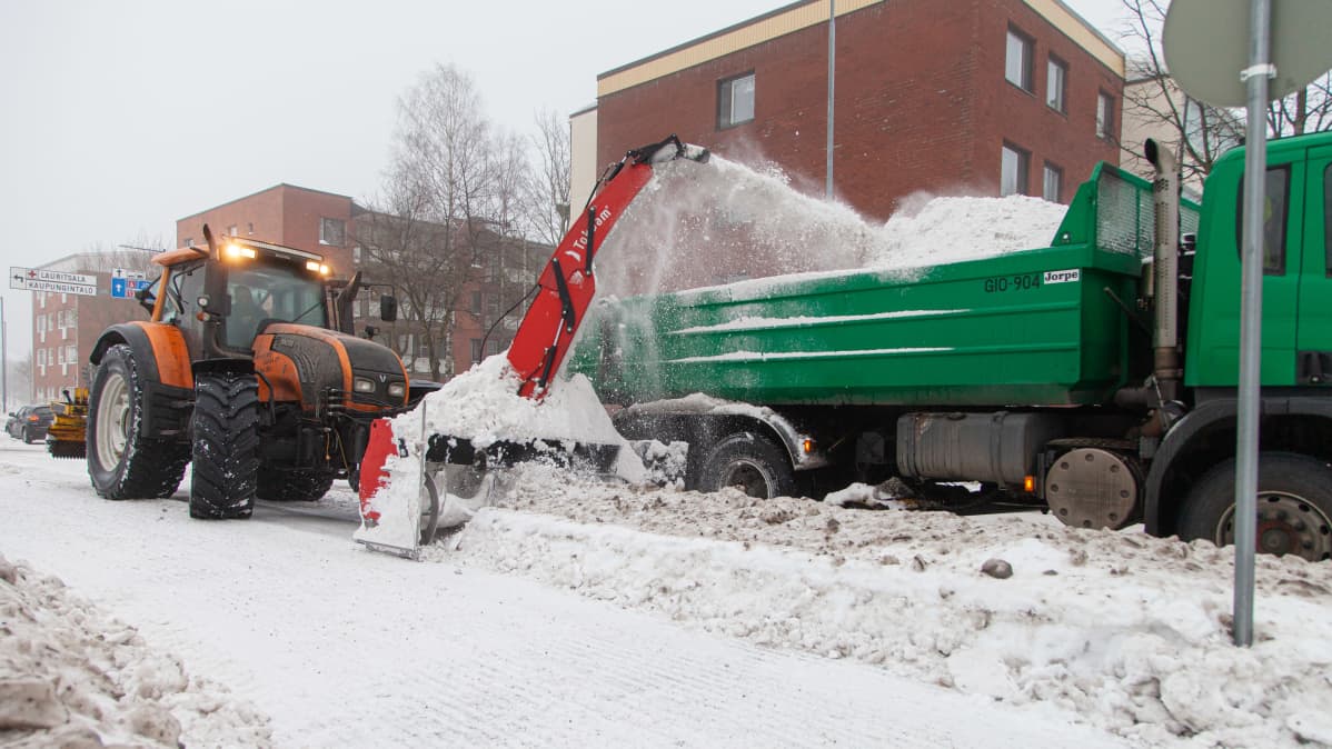 Traktoriin kiinnitetty lumilinko linkoaa lunta kadunvarresta kuorma-auton kyytiin Lappeenrannan keskustassa.