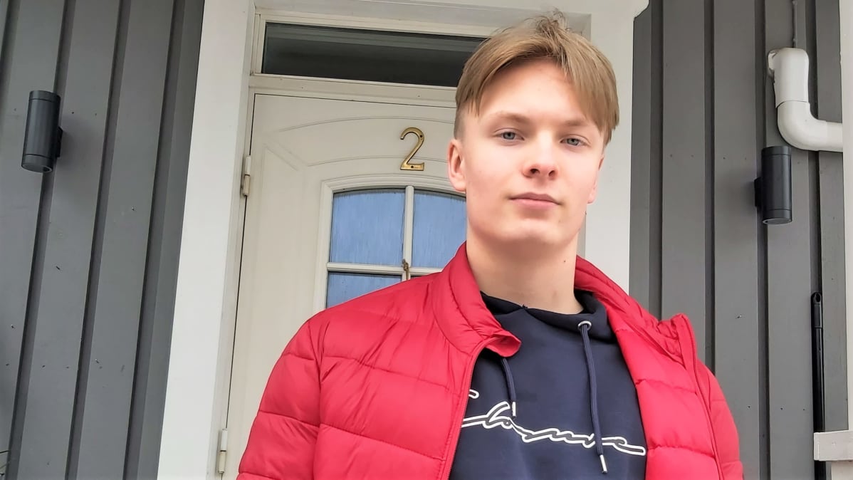 Ensihoidon opiskelija Jaro Karjalainen seisoo ryhdikkäästi talon pihalla.