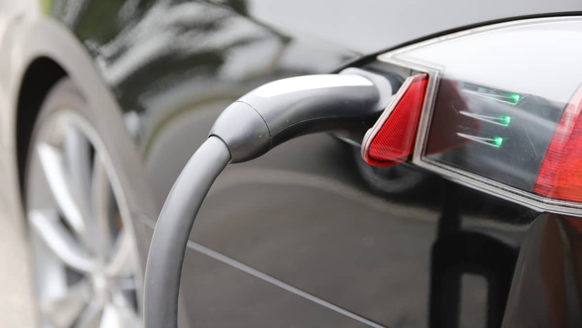 Sähköauto ja latausjohto. Sähköautojen latauspaikkoja löytyy myös kauppakeskuksista, joissa lataamisen voi hoitaa vaikka kauppareissun aikana.