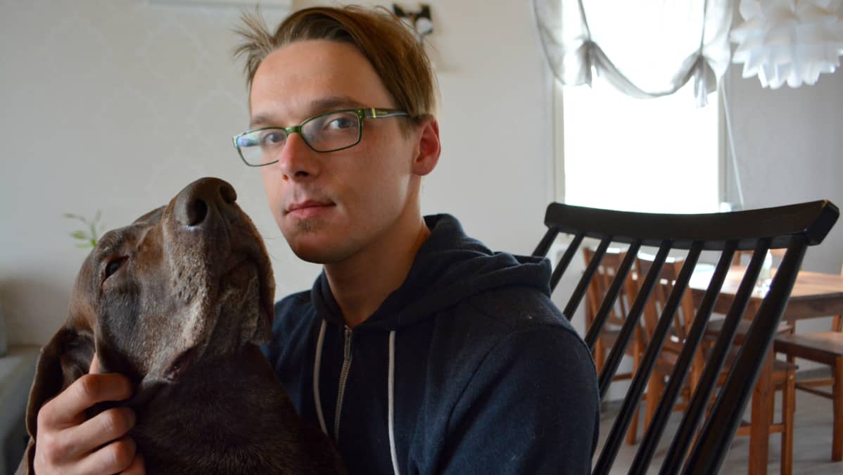 Tomi Vesterinen koira sylissään.