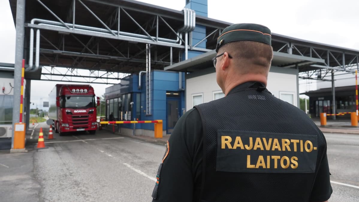 Rajavartija katsoo tarkastukseen tulevaa rekkaa Niiralassa