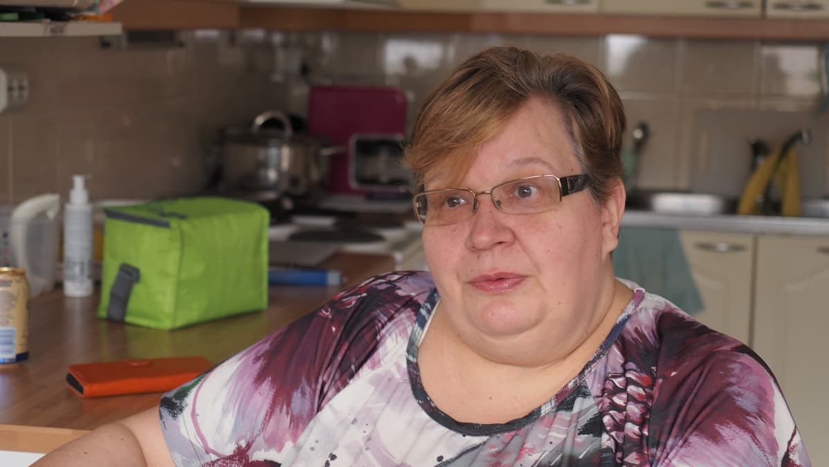 Nainen keittiönpöydän ääressä