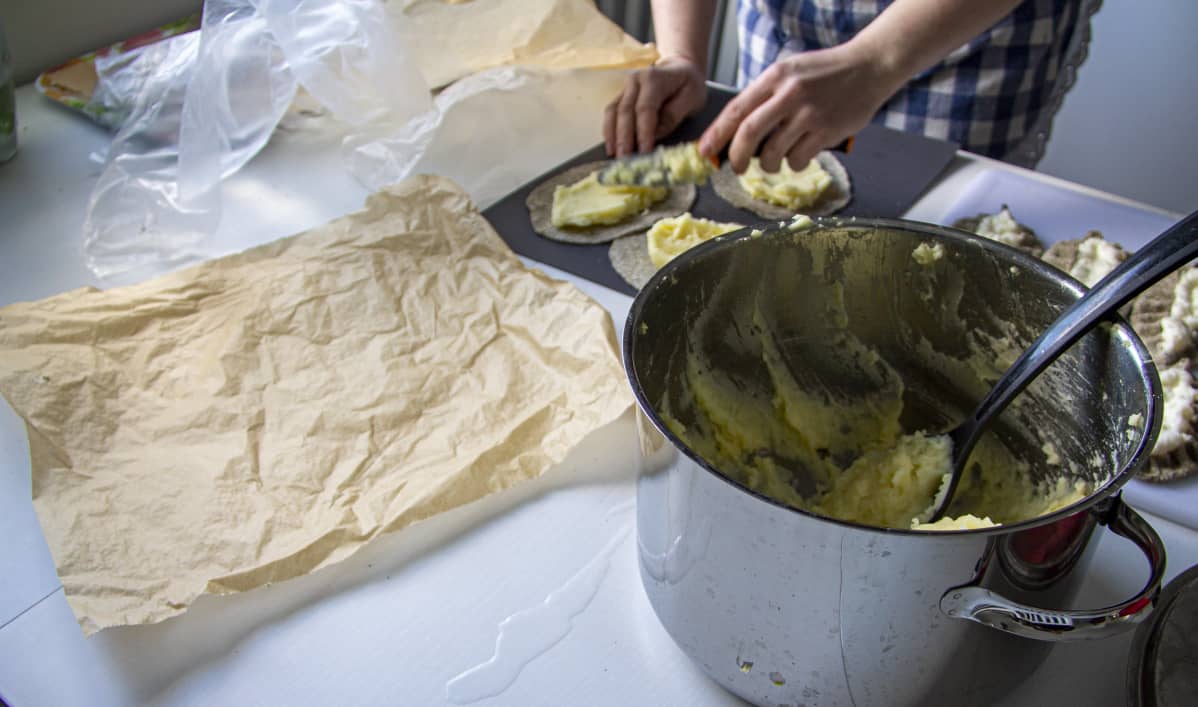 Kerttu Heikkilä leipomassa karjalanpiirakoita.