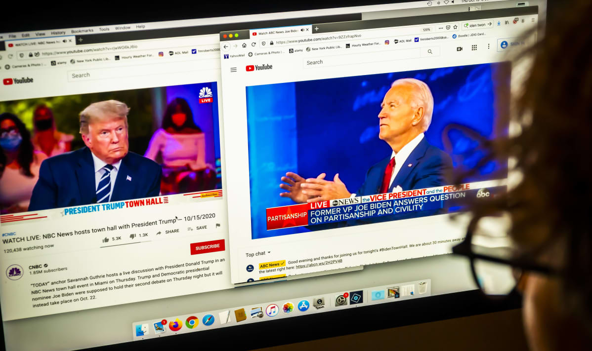 Tietokoneen näytöllä näkyy kaksi eri videota television samanaikaisista vaaliohjelmista. Toisessa on Donald Trump ja toisessa Joe Biden.