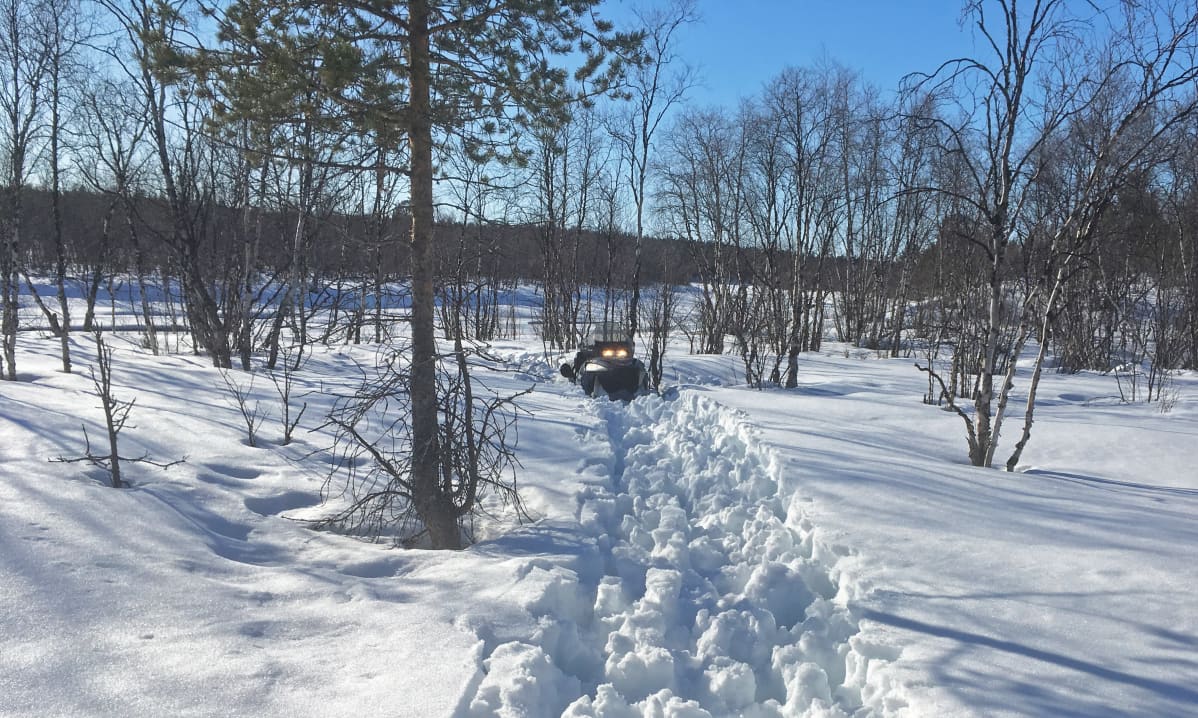 Moottorikelkka on jäänyt kiinni hankeen.