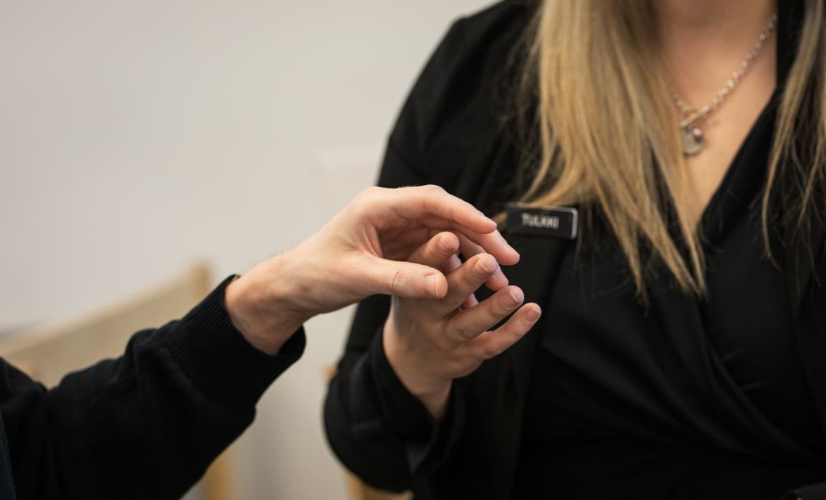 Kuulonäkövammainen keskustelee taktiileilla tulkin kanssa
