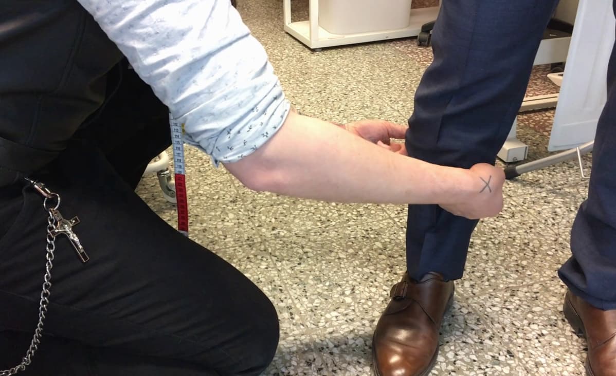 Ompelija mittaa housun lahkeita lyhennystä varten.