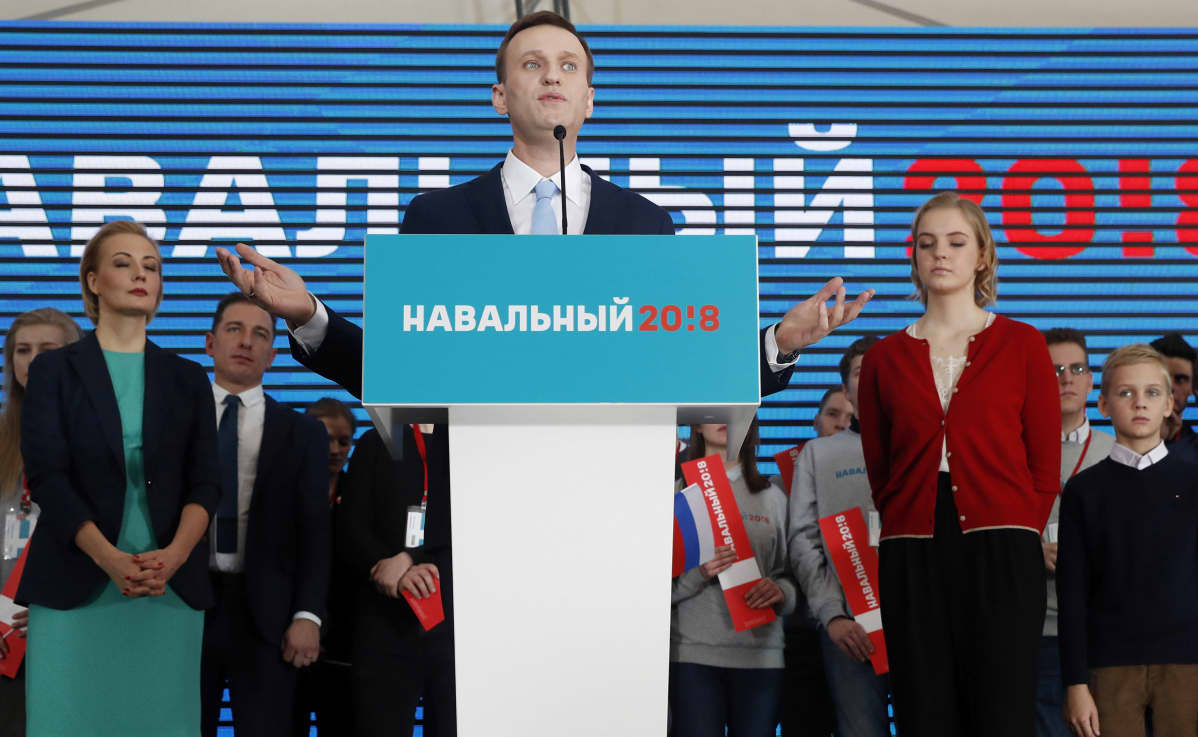 Navalnyi puhujalavalla, taustalla puoliso Julija, tukijoita ja teksti Navalnyi 2018