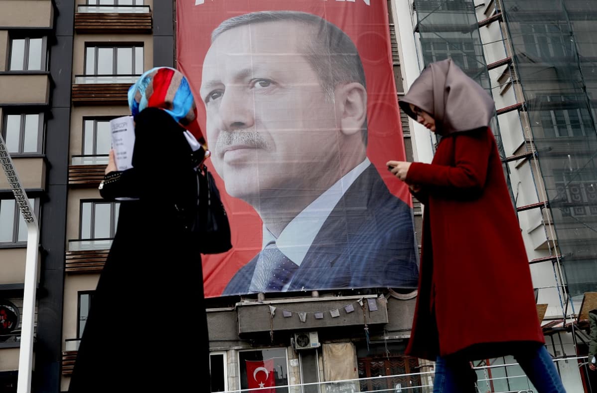 Isossa katujulisteessa Erdoğanin potrettikuva, ohi kävelee kaksi naista huivit päässä.